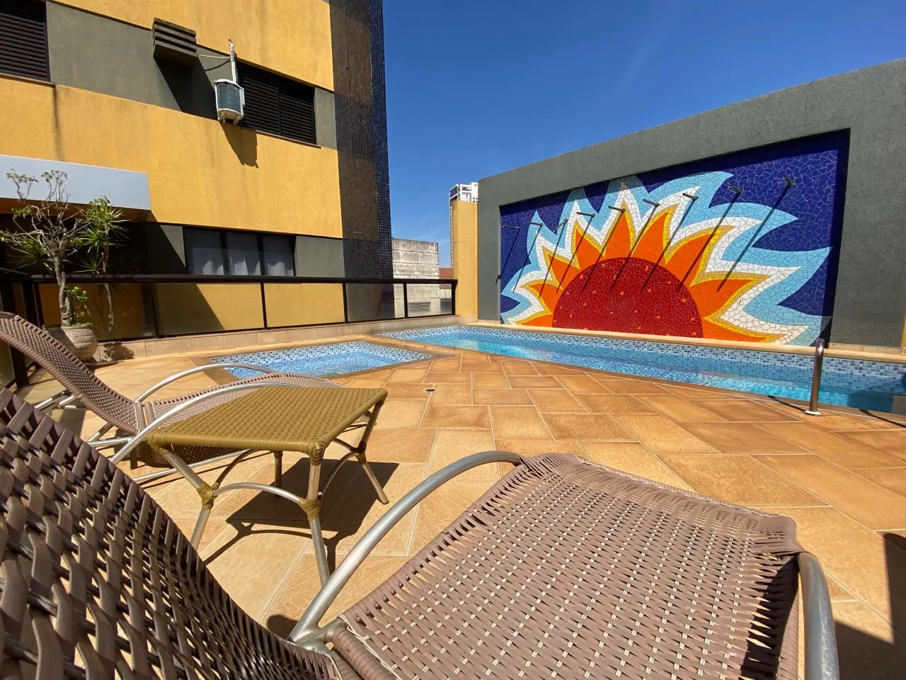 Piscina com painel de mosaico do sol